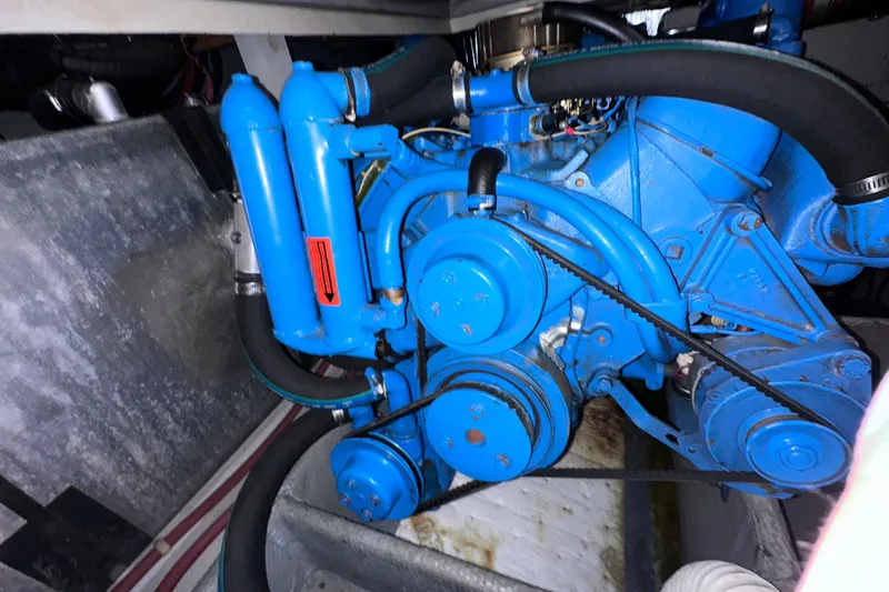 Slide: The Image of Engine of a 1988 Silverton 37 Convertible boat, painted blue with visible belts and hoses. - 38