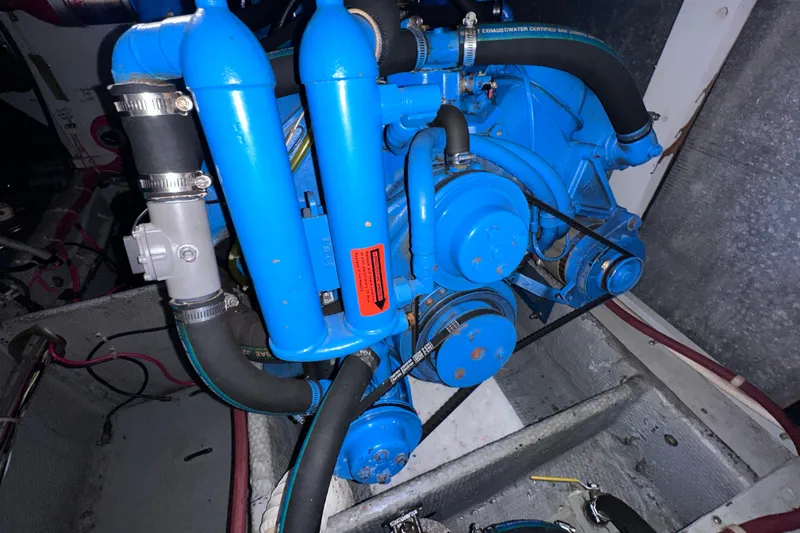 Slide: The Image of Engine compartment of a 1988 Silverton 37 Convertible boat, featuring a blue engine. - 39