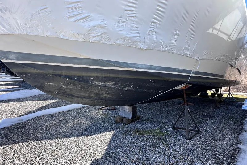 Slide: The Image of 1988 Silverton 37 Convertible boat on stands, covered and stored outdoors. - 4