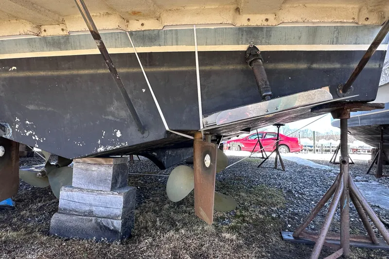 Slide: The Image of 1988 Silverton 37 Convertible boat hull on stands, showing propellers and rudders. - 7