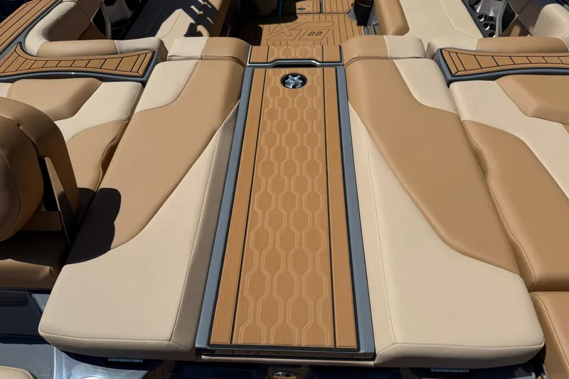 Slide: The Image of 2025 MasterCraft XT22 boat interior with tan and beige cushioned seating. - 13