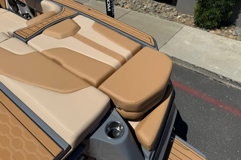 Slide: The Image of 2025 MasterCraft XT22 boat with tan and beige seating, cup holder, and sleek design. - 14