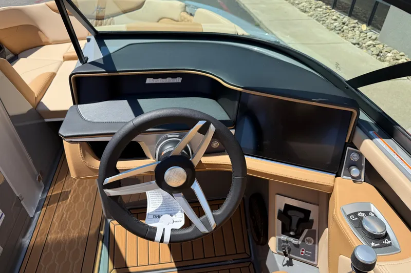 Slide: The Image of 2025 MasterCraft XT22 boat dashboard with steering wheel and touchscreen display. - 16