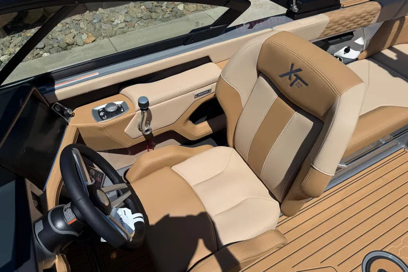Slide: The Image of 2025 MasterCraft XT22 boat interior with tan leather seating and modern controls. - 18