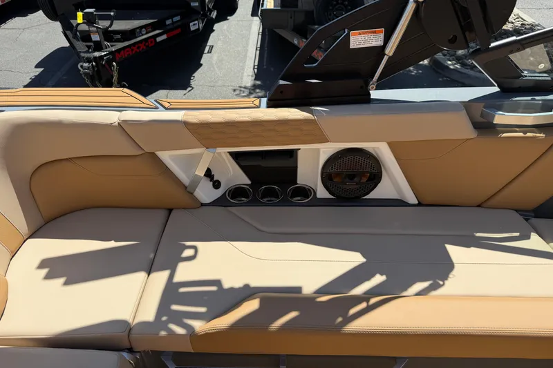 Slide: The Image of 2025 MasterCraft XT22 boat interior with beige seating and built-in speaker system. - 23