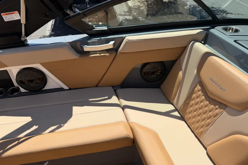 Slide: The Image of 2025 MasterCraft XT22 boat interior with tan leather seating and built-in speakers. - 24