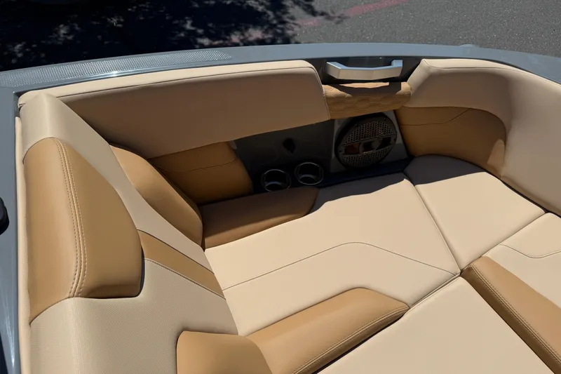 Slide: The Image of 2025 MasterCraft XT22 boat interior with beige and tan seating, featuring built-in speakers. - 27