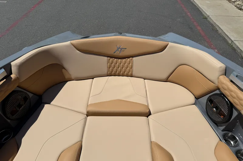 Slide: The Image of 2025 MasterCraft XT22 boat interior with tan upholstery and integrated speakers. - 28