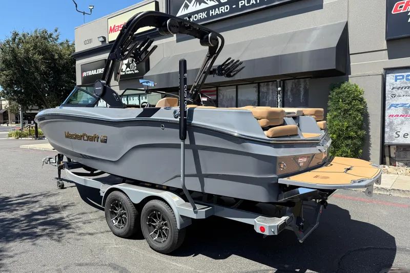 Slide: The Image of 2025 MasterCraft XT22 boat on trailer, gray exterior, parked outside dealership. - 3
