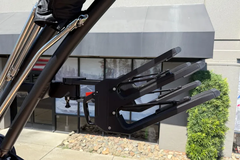 Slide: The Image of 2025 MasterCraft XT22 wakeboard rack on a boat tower, outdoor setting. - 31