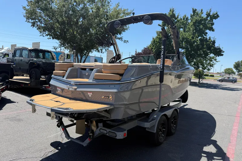 Slide: The Image of 2025 MasterCraft XT22 boat on trailer, parked outdoors, showcasing sleek design and modern features. - 5