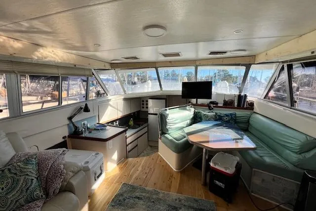 Slide: The Image of 1989 Trojan 12 Meter Motor Yacht interior with seating, kitchenette, and panoramic windows. - 11
