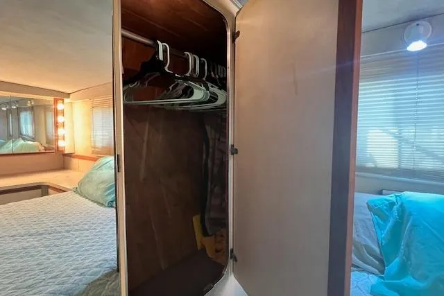 Slide: The Image of 1989 Trojan 12 Meter Motor Yacht interior with open closet and cozy bedroom. - 25