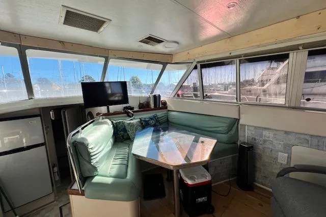 Slide: The Image of 1989 Trojan 12 Meter Motor Yacht interior with seating, table, and windows. - 28