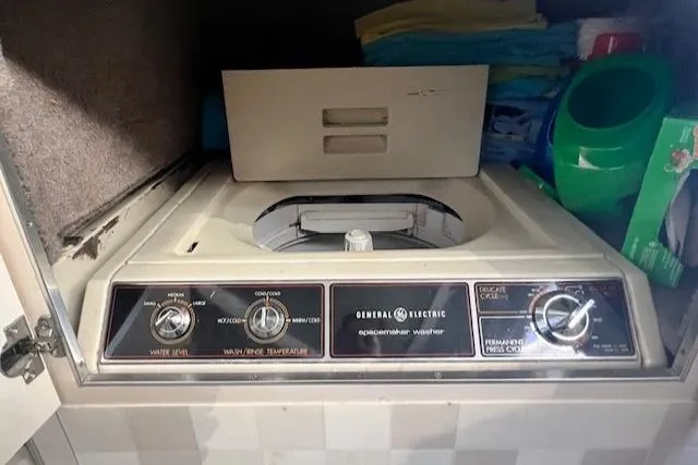 Slide: The Image of General Electric washer inside 1989 Trojan 12 Meter Motor Yacht, surrounded by laundry supplies. - 32