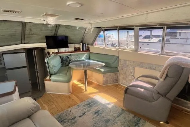 Slide: The Image of Interior of 1989 Trojan 12 Meter Motor Yacht with seating, table, and windows. - 34