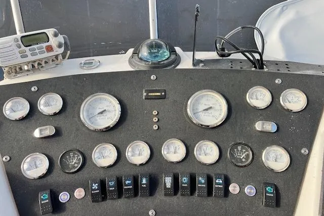 Slide: The Image of Control panel of a 1989 Trojan 12 Meter Motor Yacht with gauges and switches. - 36