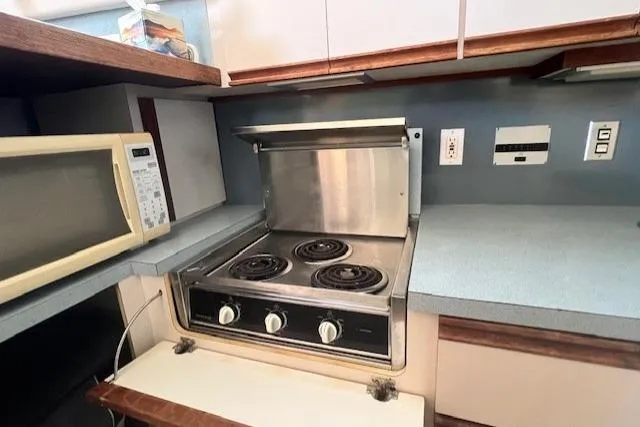 Slide: The Image of 1989 Trojan 12 Meter Motor Yacht kitchen with stove and microwave. - 38