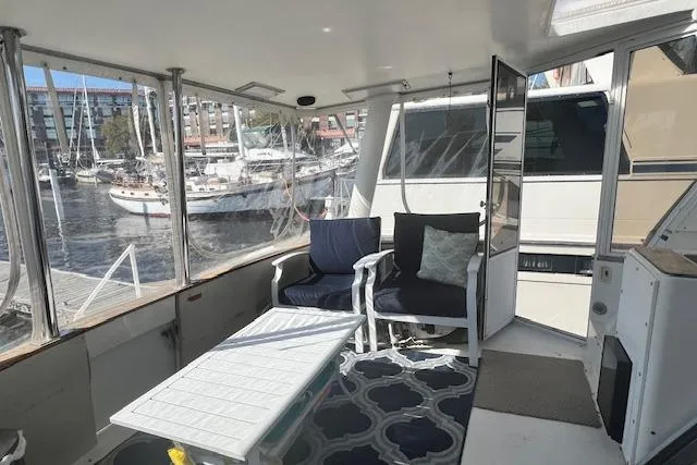 Slide: The Image of 1989 Trojan 12 Meter Motor Yacht interior with seating, table, and marina view. - 43