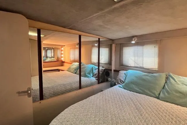 Slide: The Image of Cozy bedroom interior of 1989 Trojan 12 Meter Motor Yacht with mirrored closet and soft lighting. - 47