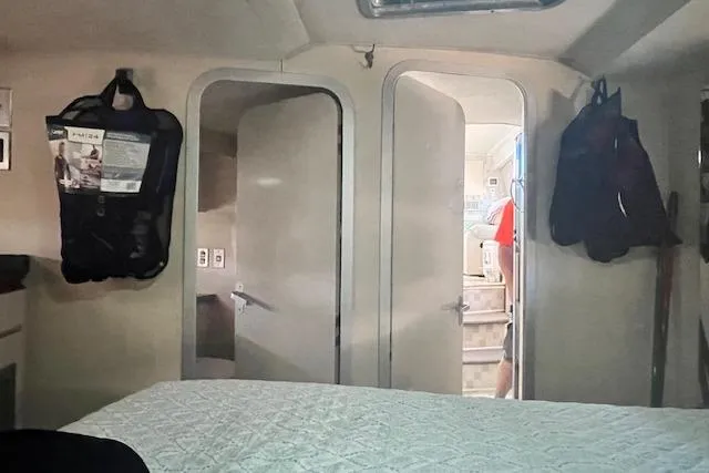 Slide: The Image of Interior of a 1989 Trojan 12 Meter Motor Yacht cabin with doors and hanging bags. - 49