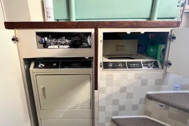 Slide: The Image of Laundry area inside a 1989 Trojan 12 Meter Motor Yacht with appliances and storage. - 58