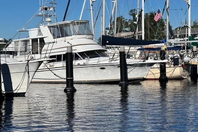 Slide: The Image of 1989 Trojan 12 Meter Motor Yacht docked in a marina, surrounded by other boats. - 6