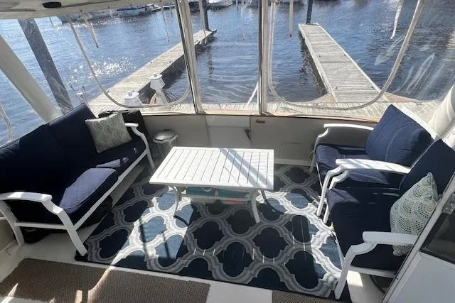 Slide: The Image of 1989 Trojan 12 Meter Motor Yacht interior with seating, table, and waterfront view. - 8