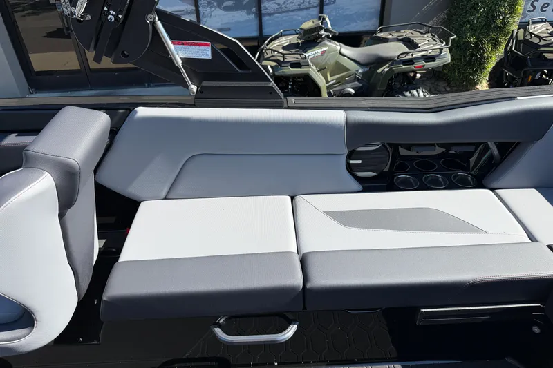 Slide: The Image of 2026 MasterCraft NXT24 boat interior with gray and white seating, cup holders, and sleek design. - 17