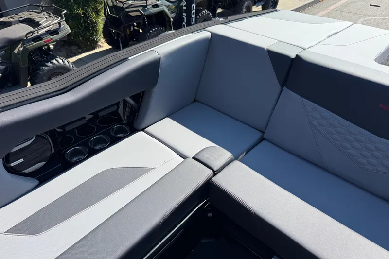 Slide: The Image of 2026 MasterCraft NXT24 boat interior with gray seating and cup holders. - 18