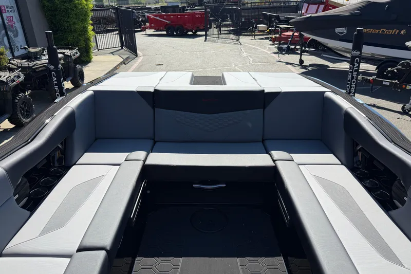 Slide: The Image of 2026 MasterCraft NXT24 boat interior with gray seating and cup holders. - 19