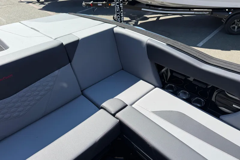Slide: The Image of 2026 MasterCraft NXT24 boat interior with gray seating and cup holders. - 20