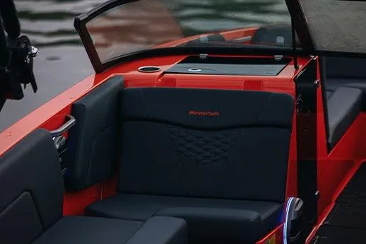 Slide: The Image of 2026 MasterCraft NXT24 boat on trailer, parked outdoors, showcasing sleek black design. - 6