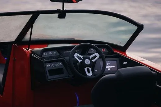 Slide: The Image of 2026 MasterCraft NXT24 boat on trailer, parked outdoors near trees. - 7