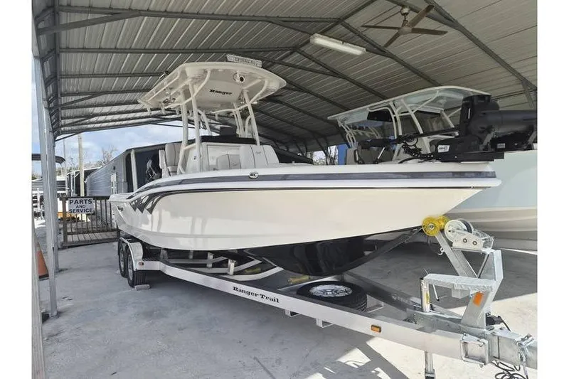 The Image of 2026 Ranger 2600 Bay boat on trailer under metal canopy. - 0