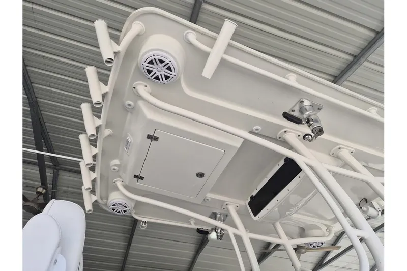 Slide: The Image of 2026 Ranger 2600 Bay boat's T-top with rod holders and speakers in a covered area. - 13
