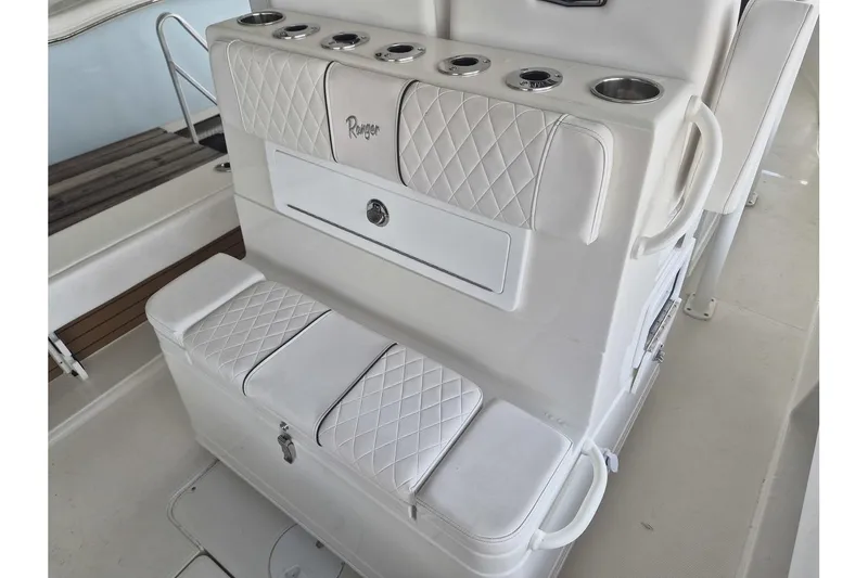 Slide: The Image of 2026 Ranger 2600 Bay boat interior with white quilted seating and cup holders. - 16