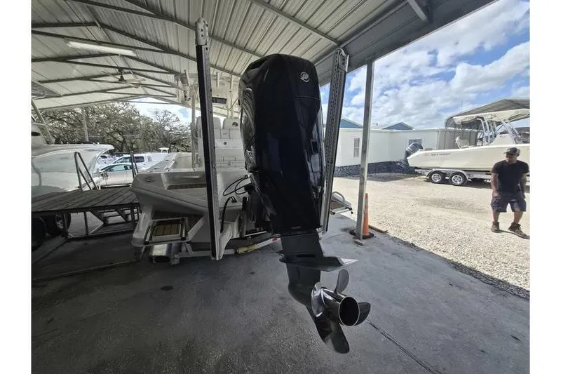 Slide: The Image of 2026 Ranger 2600 Bay boat with outboard motor in covered storage area. - 2