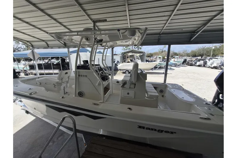 Slide: The Image of 2026 Ranger 2600 Bay boat under a metal canopy in a marina setting. - 3
