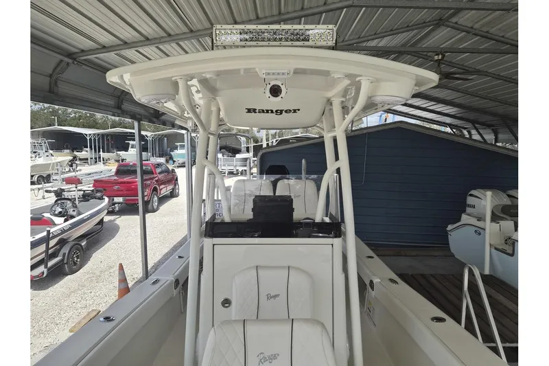 Slide: The Image of 2026 Ranger 2600 Bay boat under a metal canopy, showcasing interior and console. - 9