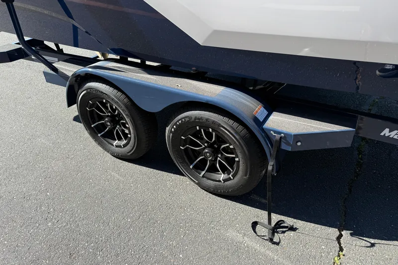 Slide: The Image of Trailer wheels of 2026 MasterCraft NXT23 boat on pavement. - 10