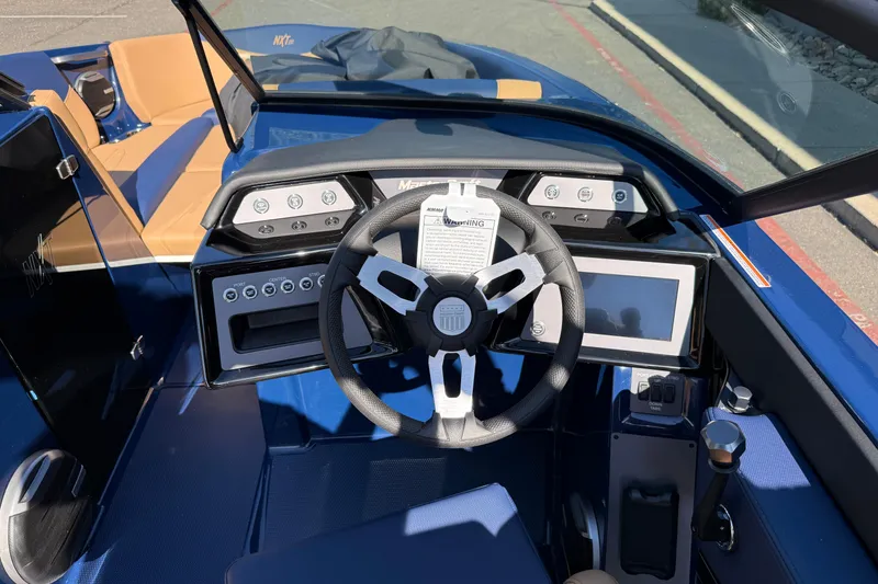 Slide: The Image of 2026 MasterCraft NXT23 boat dashboard with steering wheel and control panel. - 13