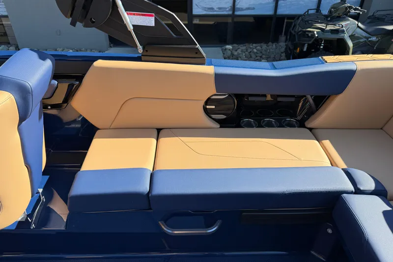 Slide: The Image of 2026 MasterCraft NXT23 boat interior with blue and tan seating, cup holders, and sleek design. - 16