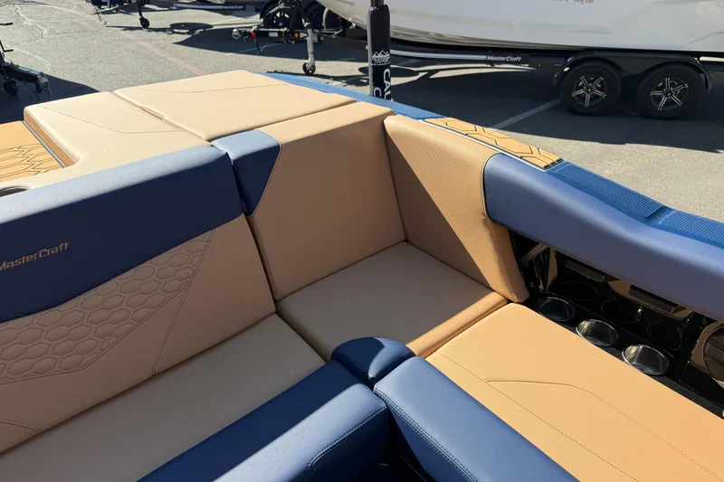 Slide: The Image of 2026 MasterCraft NXT23 boat interior with tan and blue seating, showcasing luxury design. - 19