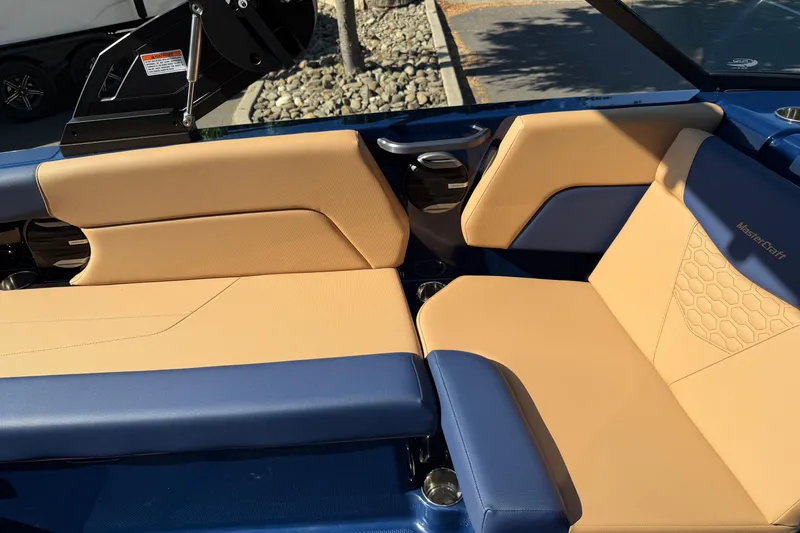 Slide: The Image of 2026 MasterCraft NXT23 boat interior with tan and blue seating, showcasing luxury design. - 21