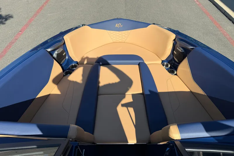 Slide: The Image of 2026 MasterCraft NXT23 boat interior with tan and blue seating. - 24