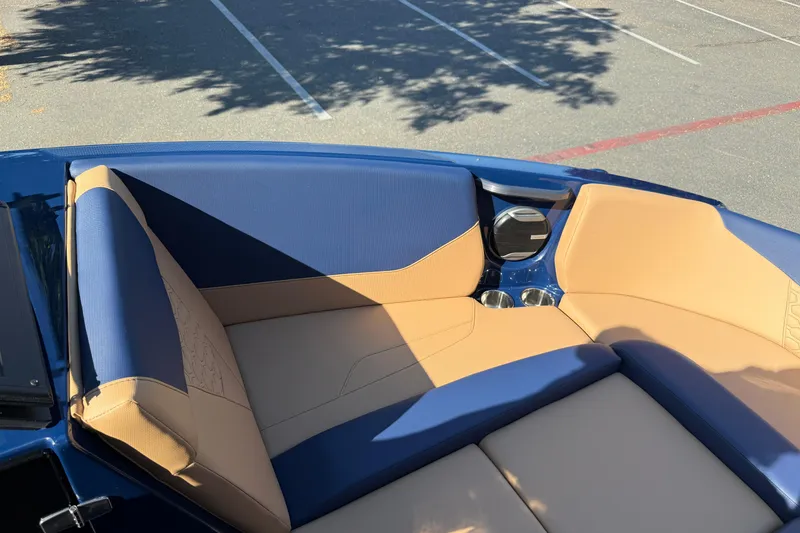 Slide: The Image of 2026 MasterCraft NXT23 boat interior with blue and tan seating, cup holders visible. - 25