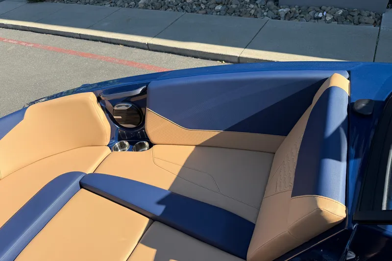 Slide: The Image of 2026 MasterCraft NXT23 boat interior with tan and blue seating, cup holders, and sleek design. - 27