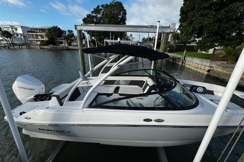 Slide: The Image of 2023 Monterey M-225 boat docked, featuring sleek design and Mercury engine. - 16