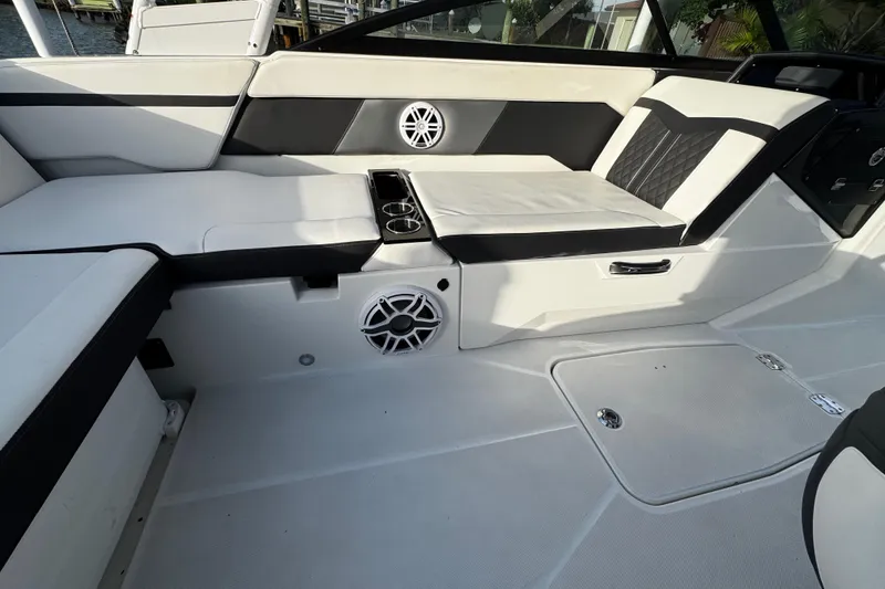 Slide: The Image of 2023 Monterey M-225 boat interior with white seating, cup holders, and speaker. - 20